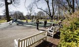 Wijkagenten in een park in Den Haag controleren  of mensen zich aan de coronamaatregelen houden.