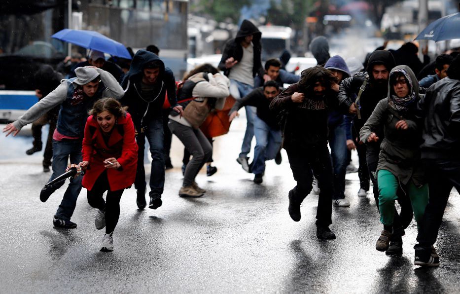 Omstanders en betogers slaan op de vlucht voor traangas dat de Turkse politie vandaag inzette bij rellen in Ankara.