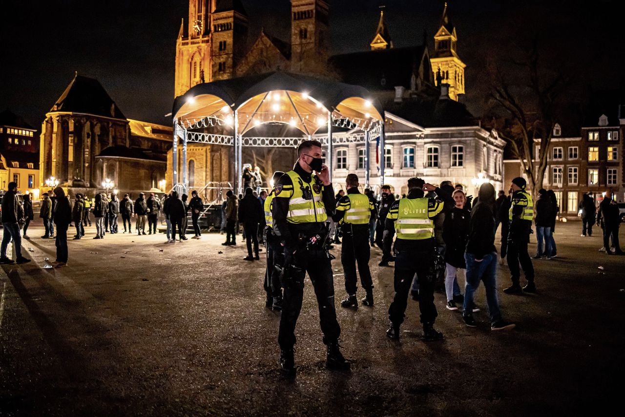 Politie-agenten en MVV- supporters van de Angel Side op het Vrijthof in Maastricht. De supporters zeiden de stad te willen beschermen.