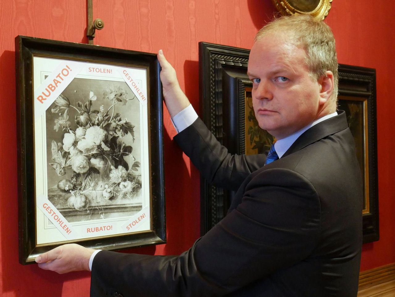 Directeur van de Uffizi-galerijen Eike Schmidt met een reproductie van Vaas met bloemen, waarop staat dat het origineel gestolen is.
