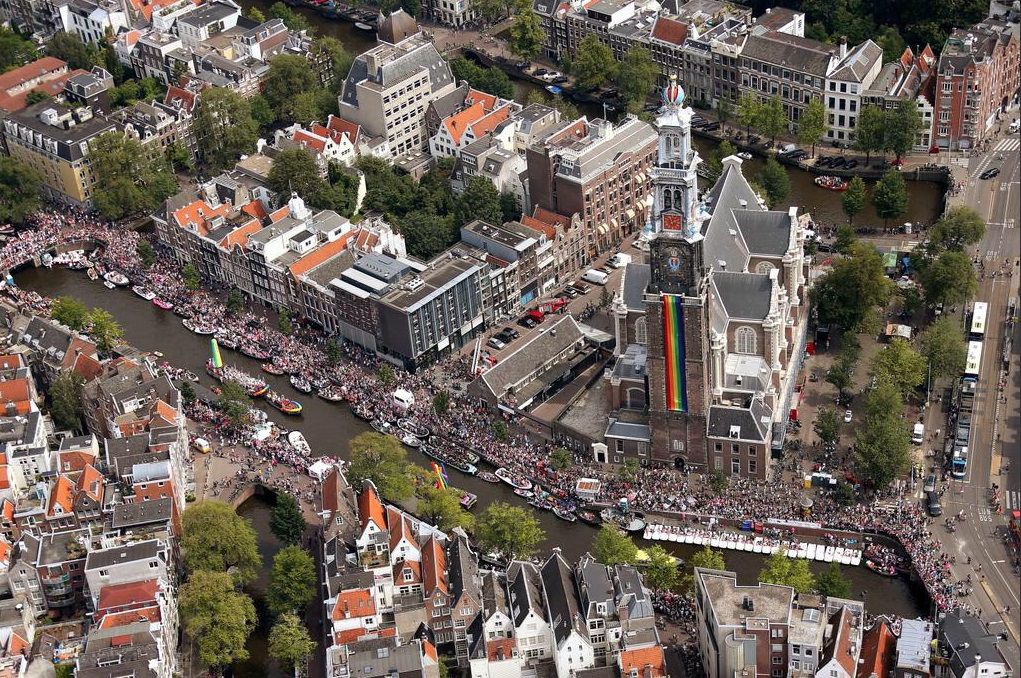 Een luchtfoto van de drukte in de Amsterdamse binnenstad tijdens de Canal Parade van de Gay Pride.