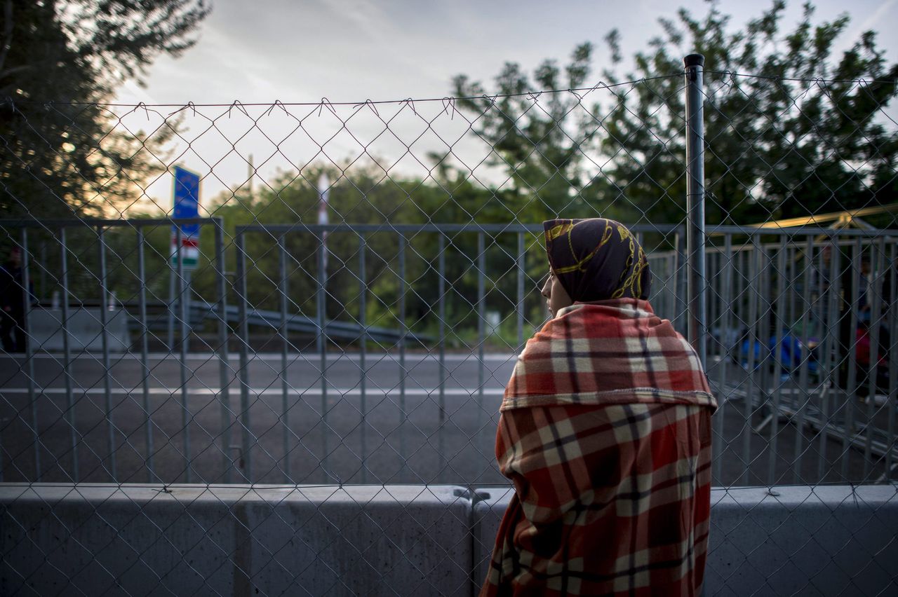 Een migrant bij een gesloten grensovergang tussen Hongarije en Servië.