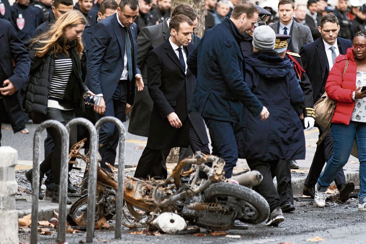 President Macron bekijkt de schade bij de Champs-Élysées.