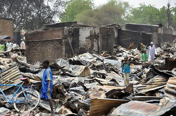 Inwoners lopen langs uitgebrande winkels in Ngala na een aanval van strijders van Boko Haram.