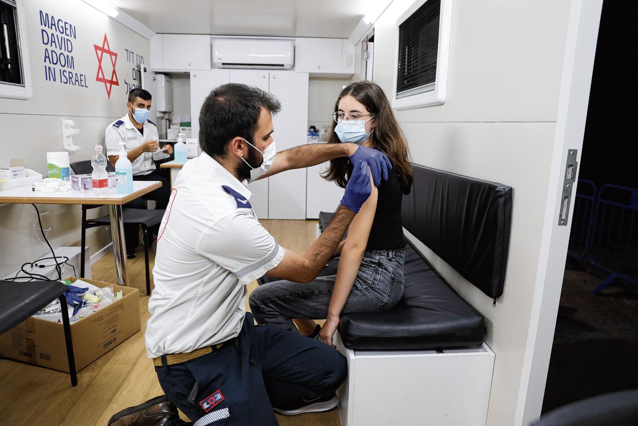 Vaccinaties van tieners in de steden Tel Aviv (boven) en Rishon LeZion. Foto’s Sebastian Scheiner / AP, Abir Sultan / EPA