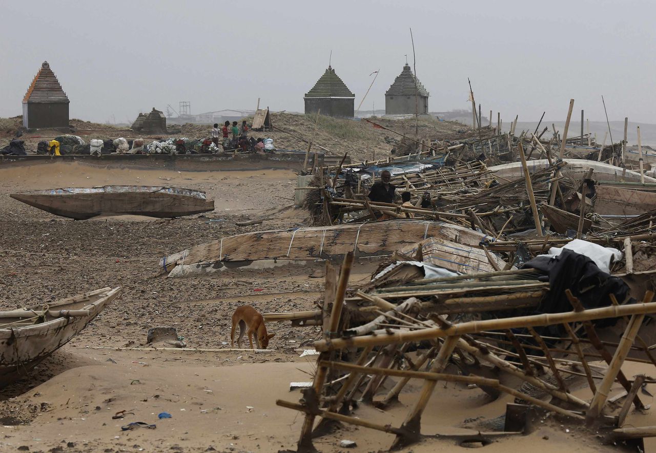 Omvergeworpen boten en chaos op het strand van Gopalpur in het oosten van India, na cycloon Phailin.