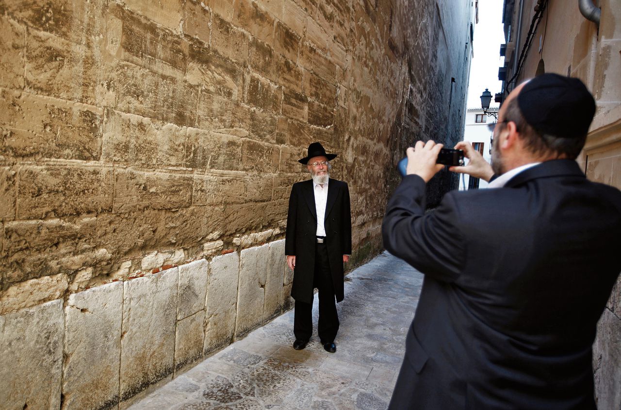Twee Joden fotograferen elkaar voor een synagoge in Palma, op het Spaanse eiland Mallorca.