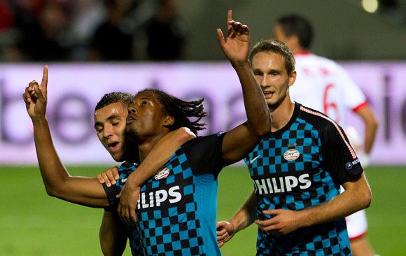 Caption: PSV Eindhoven's Georginio Wijnaldum celebrates after scoring a penalty as Hapoel Tel Aviv's Edel Apoula, right, look on during their Europa League Group C soccer match at the Bloomfield stadium in Tel Aviv, Israel,Thursday, Oct. 20, 2011 . (AP Photo/Ariel Schalit)