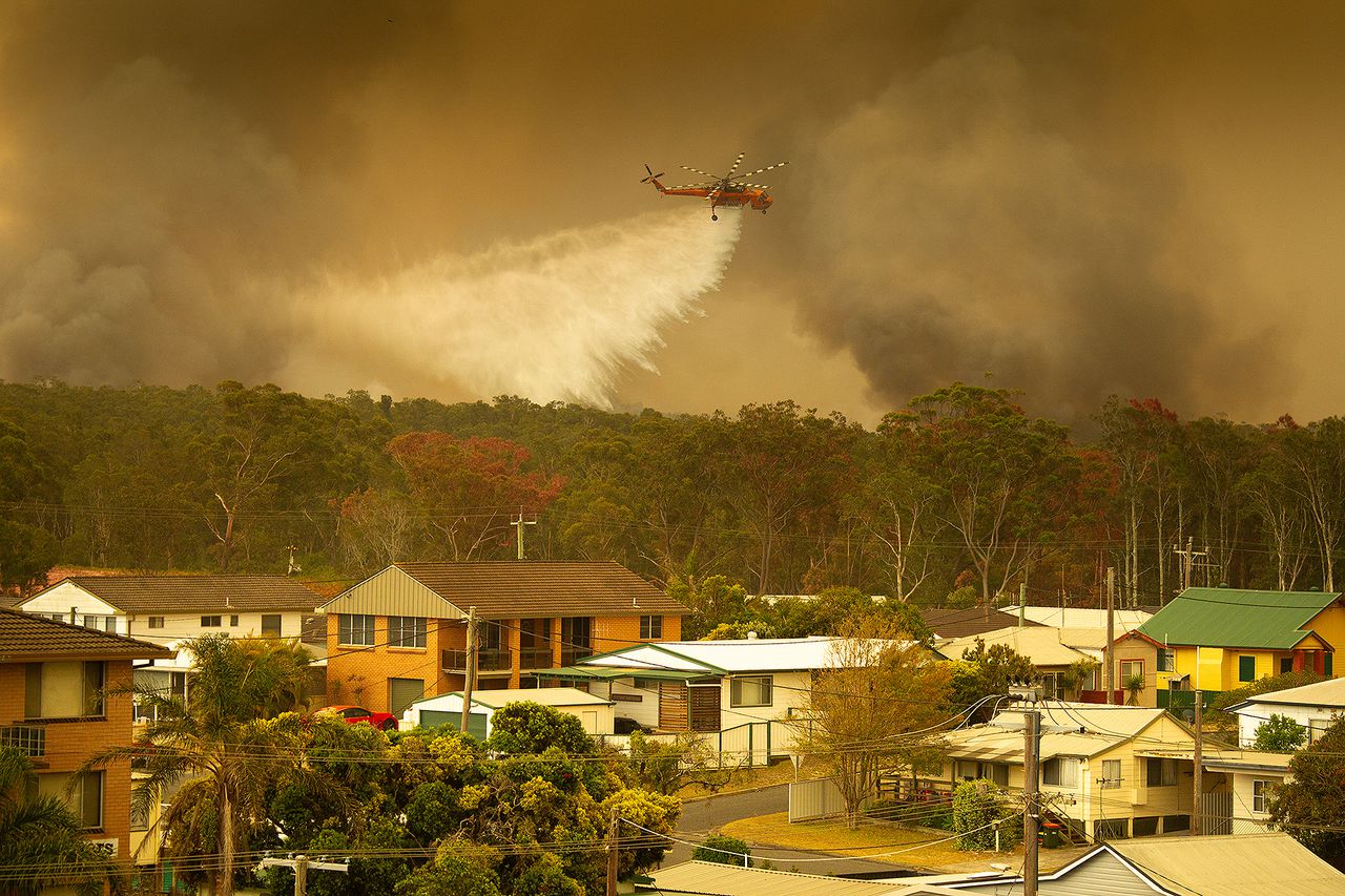 Een helikopter laat water los boven de bosbranden in Harrington, Australië.