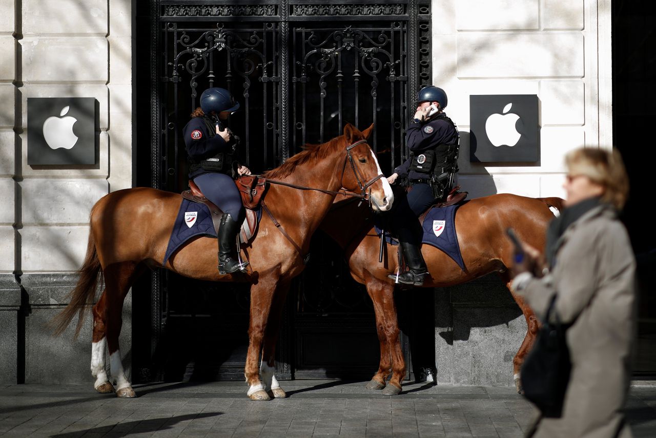 Franse politie te paard voor een Apple-winkel aan de Parijse Champs-Élysées