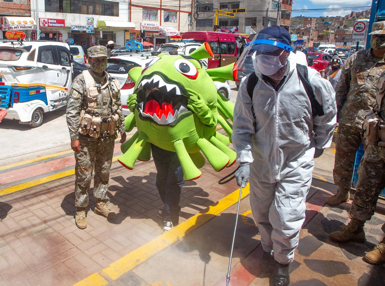 Een gemeenteambtenaar patrouilleert verkleed als virusdeeltje door de Peruaanse stad Puno om mensen te herinneren aan de coronamaatregelen..