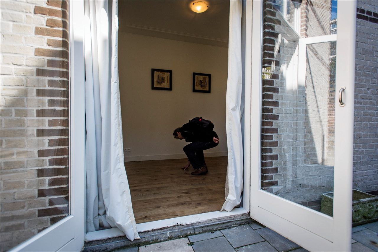 Een woningzoekende man controleert de vloer in een langdurig leegstaande woning tijdens de landelijke Open Huizen Dag van de NVM.