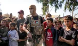 Een gemaskerde strijder van de Ezzedine al-Qassam Brigades, de gewapende tak van Hamas, houdt de wacht in Deir el-Balah.
