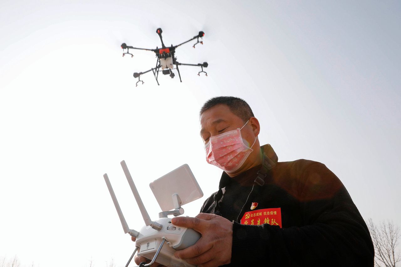 Een inwoner van Pingdingshan in de Chinese provincie Henan sproeit met een drone desinfecteermiddel in het dorp