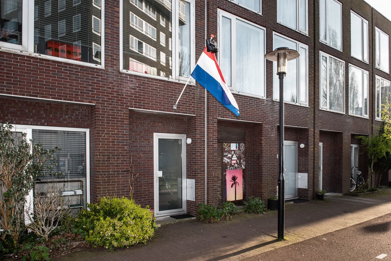 Met een schooltas aan een vlaggenstok, hier in Amsterdam, vieren scholieren traditioneel dat zij geslaagd zijn.