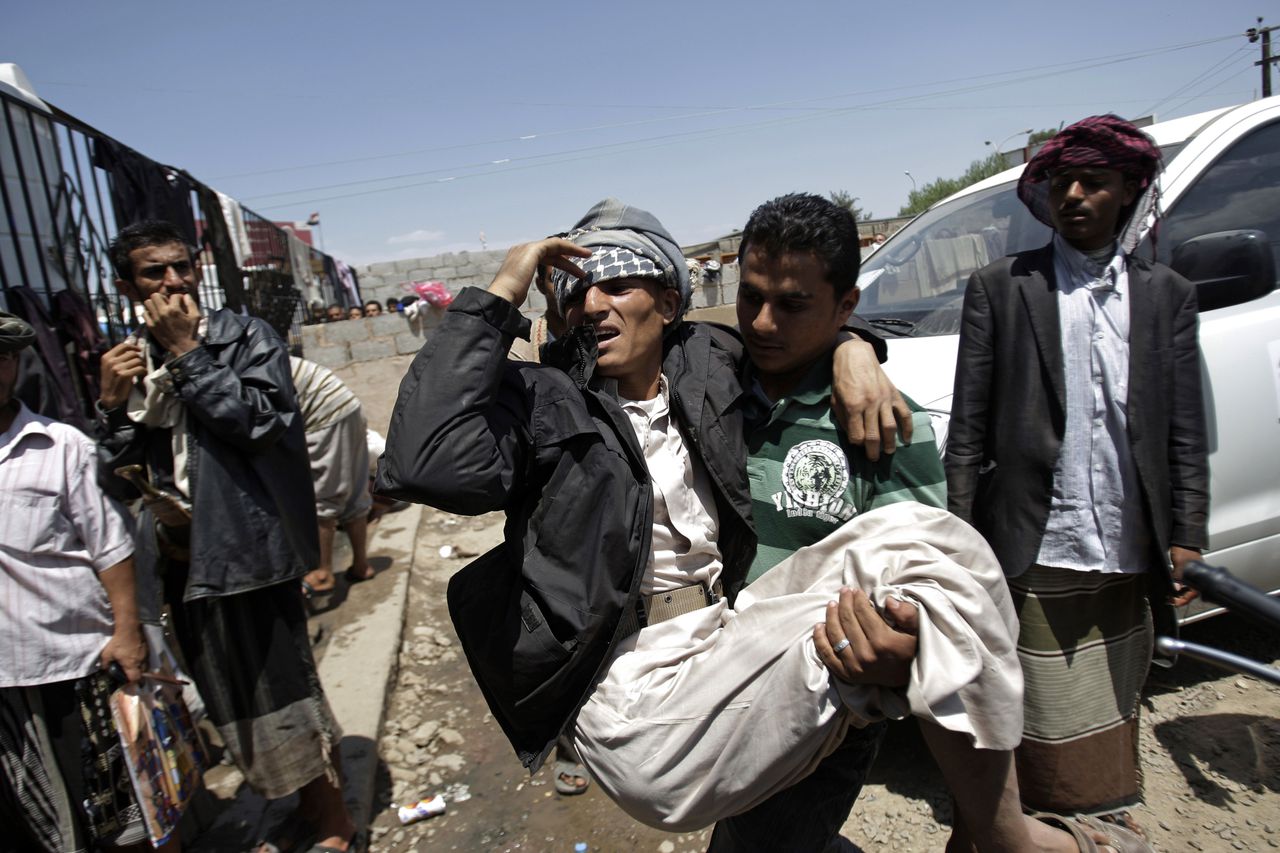 Inmiddels een bekend beeld vanuit de straten van de Jemenitische hoofdstad Sana’a: demonstranten dragen een gewonde lotgenoot naar het ziekenhuis na gevechten met regeringstroepen.