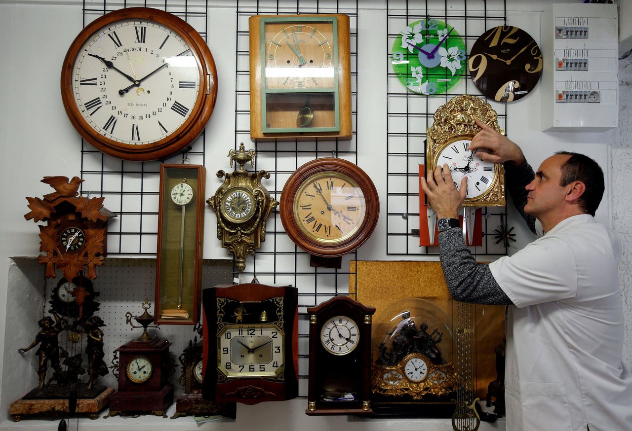 Een klokkenmaker in Frankrijk stelt zijn klokken bij.