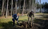 Met gedeputeerde Hagar Roijackers plant  boswachter Erik de Jonge een jonge boom. 