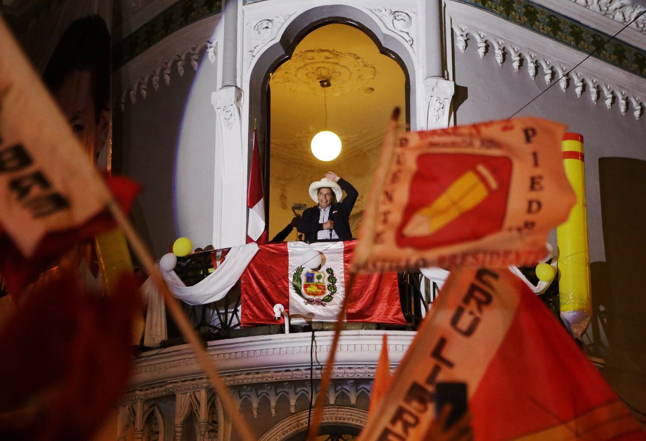 Pedro Castillo met een Peruaanse vlag bij zijn partijkantoor, op maandag – nog voordat de uitslag bekend was.