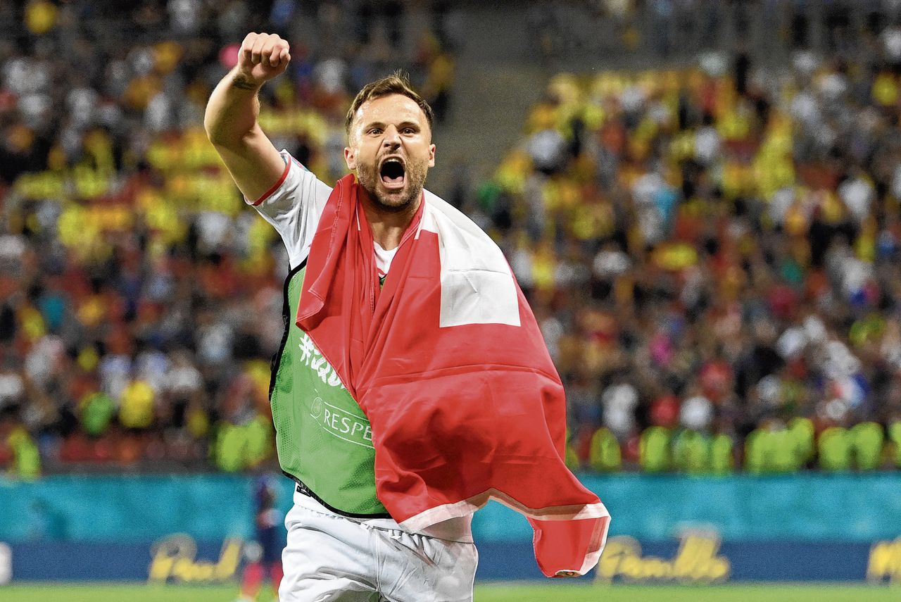 De Zwitserse aanvaller Haris Seferovic viert de zege op Frankrijk in de achtste finales, met de Zwitserse vlag om zijn schouders. Zijn roots liggen in Bosnië.