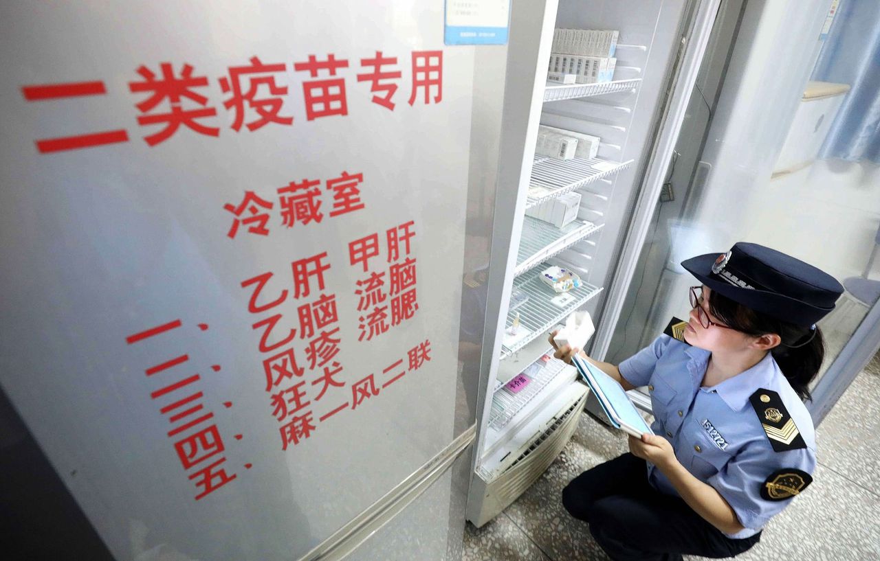 Een ambtenaar van de Chinese voedsel- en warenautoriteit controleert vaccins in een ziekenhuis in Rongan, in het zuiden van China.