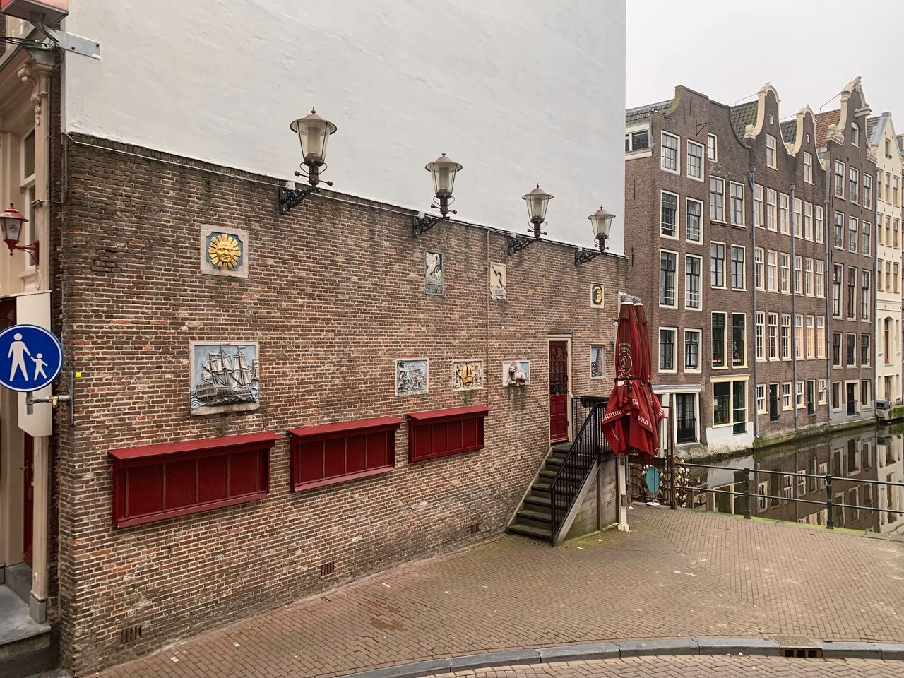 Gevelstenen langs de Wallenroute, hier op de hoek van de Oudezijds Voorburgwal en de Nieuwebrugsteeg.Foto Joël Broekaert