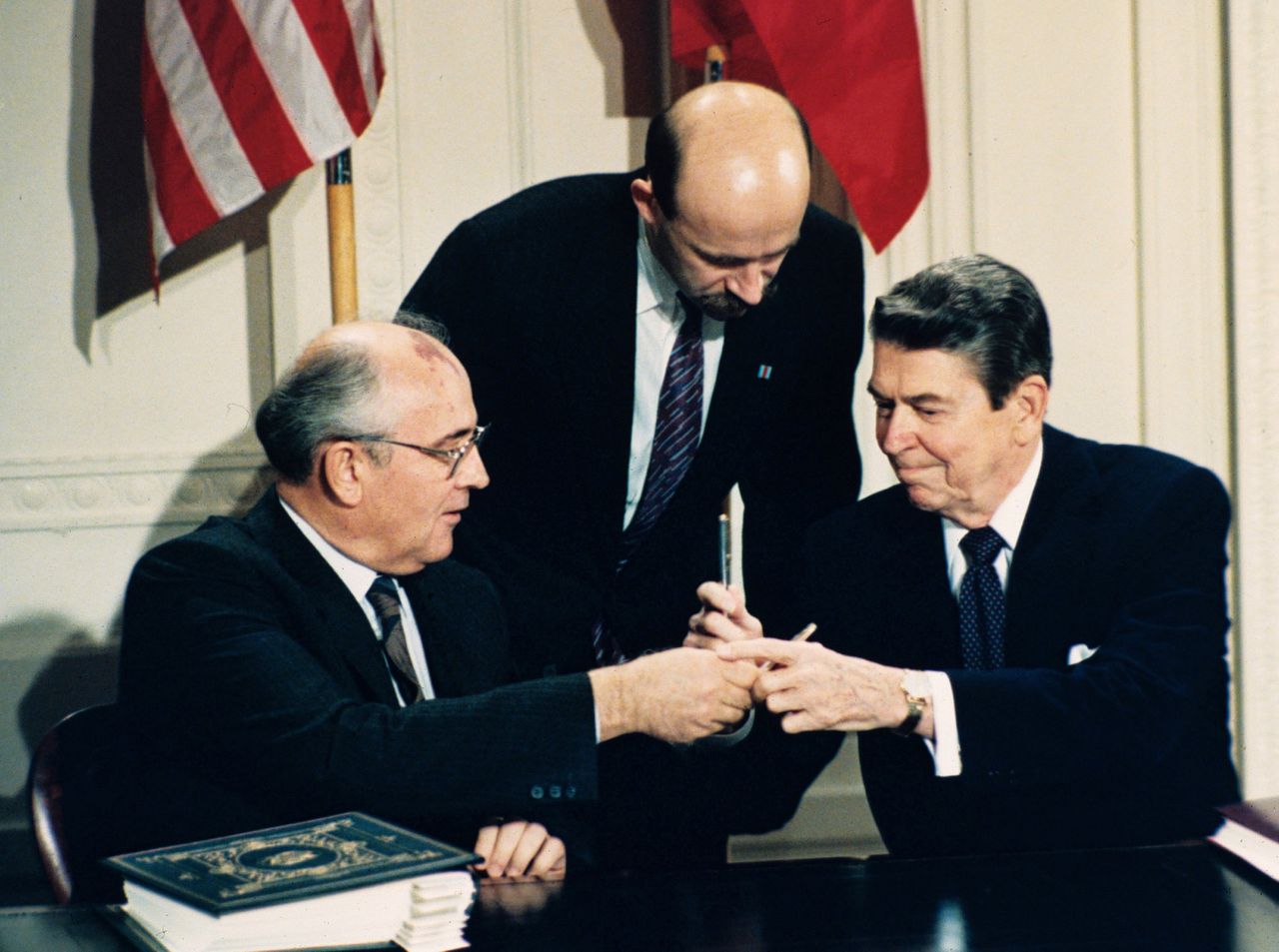 Ronald Reagan (rechts) en Michail Gorbatsjov wisselen pennen uit tijdens de ondertekening van het Intermediate Range Nuclear Forces Treaty (INF) in december 1987 op het Witte Huis