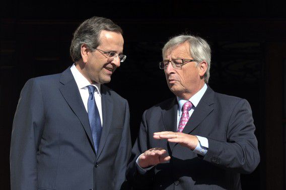 Greek prime minister Antonis Samaras (L) talks with Eurogroup chief Jean-Claude Juncker at the entrance to his office in Athens on August 22, 2012. Jean-Claude Juncker said Wednesday that he was "totally opposed" to Greece being forced out of the 17-nation bloc. Juncker added that the Greek government's "priority number one is the consolidation of the public finances, (along with) a robust and credible strategy for closing the mid term gap" in its debt-laden accounts..AFP PHOTO / LOUISA GOULIAMAKI