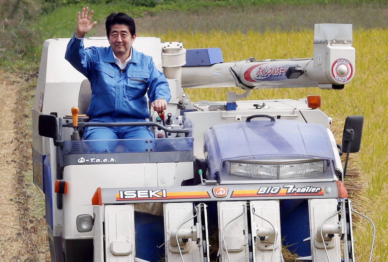 Shinzo Abe op een landbouwmachine in de buurt van de kerncentrale van Fukushima, in 2014.