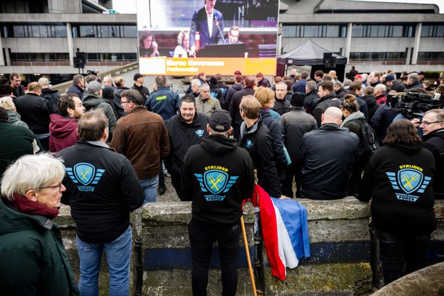 Boeren volgen via een scherm bij het provinciehuis de Statenvergadering.