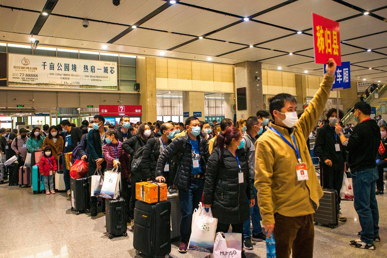 Arbeidsmigranten op het station in de stad Yichang. Reizen mag weer mondjesmaat in de provincie Hubei.