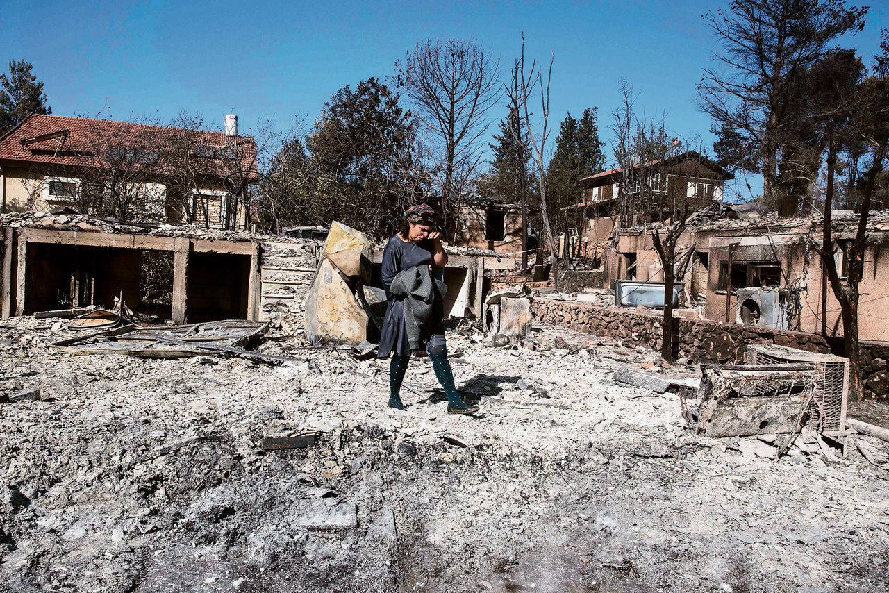Een Israëlische kolonist inspecteert haar verbrande huis in de Joodse nederzetting Halamish / Neveh Tzuf.