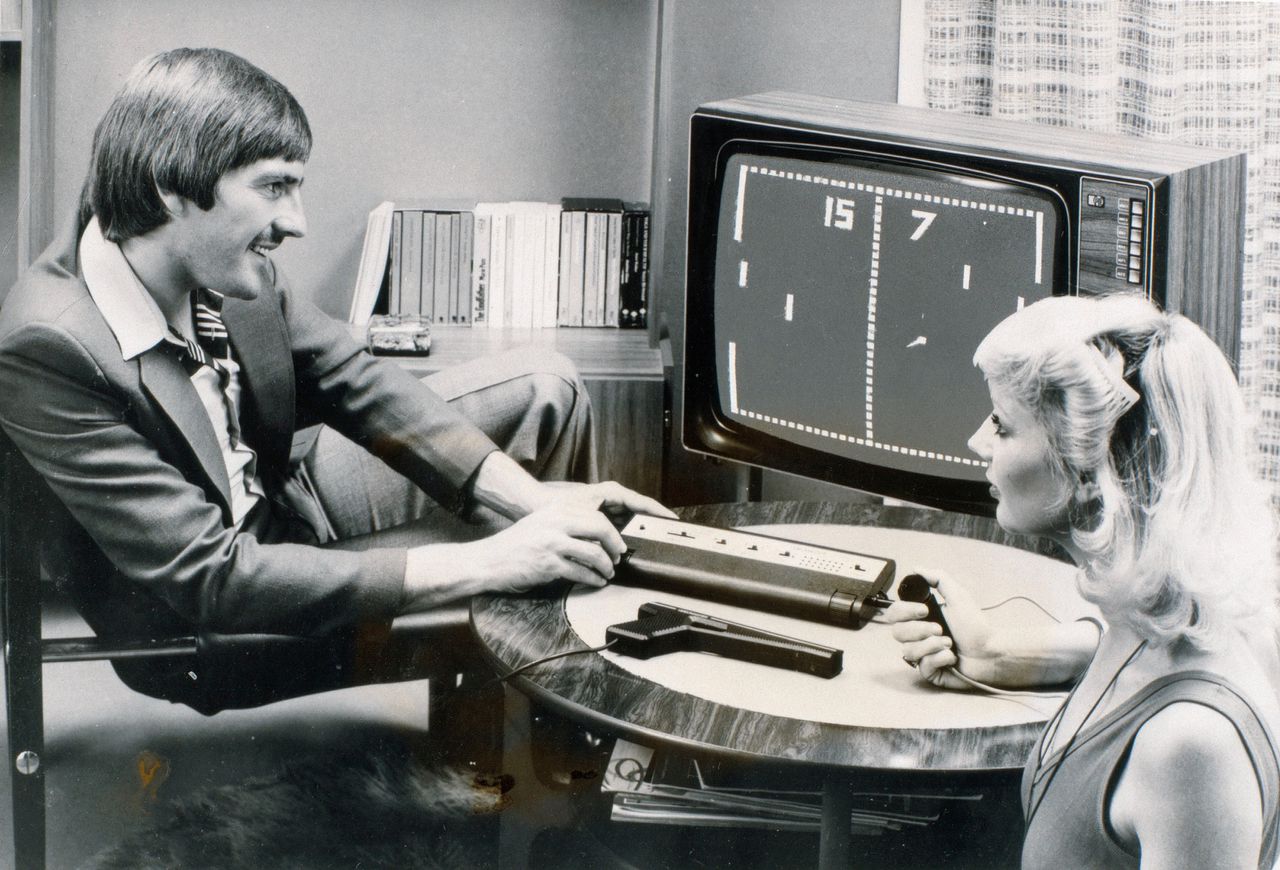 De Ierse voetballer Steve Heighway en een onbekende vrouw spelen Pong, de eerste commercieel succesvolle videogame.