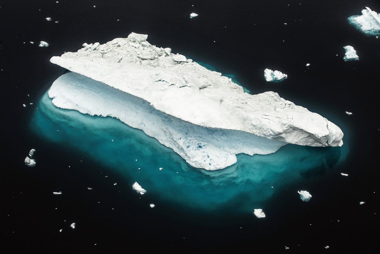 IJsbergenvoor de kust van Groenland. Zelfs als de uitstoot van broeikasgassen sterk wordt teruggedrongen, blijven de oceanen nog een tijd verder opwarmen.