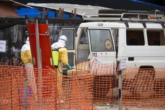 Een auto die wordt gebruikt voor het vervoer van aan ebola overleden patiënten wordt ontsmet bij een ziekenhuis in Guinee.