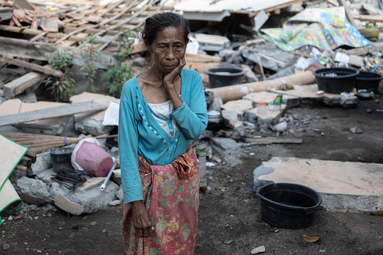 Een vrouw overziet de schade aan haar huis in het dorp Labu Pandan.