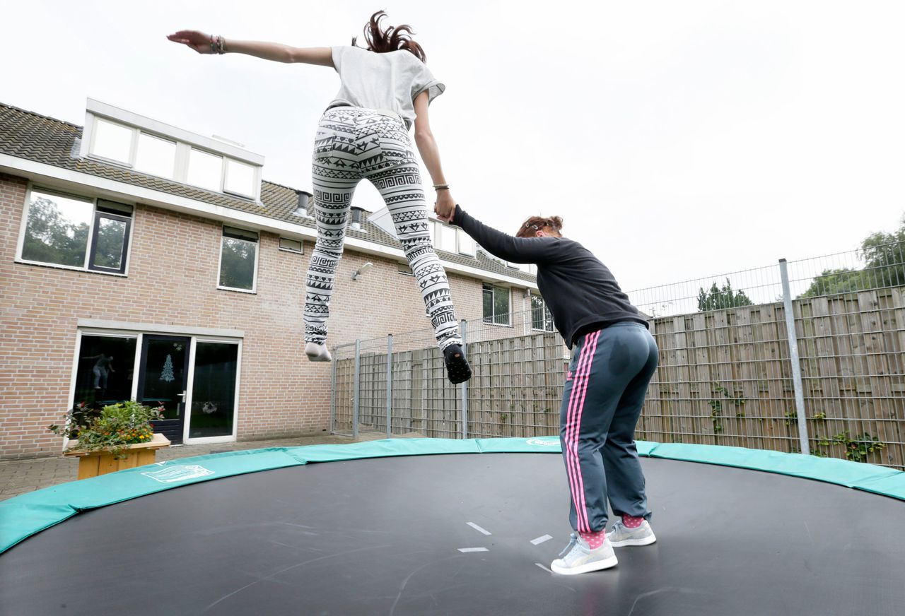 Twee meisjes van internaat Lievenshove van zorginstelling Juzt op de trampoline in de tuin.