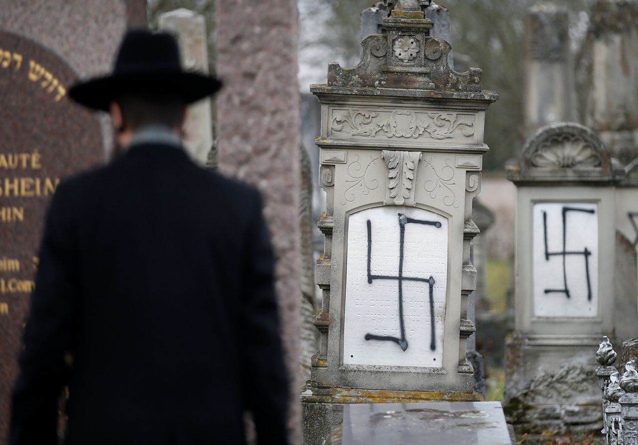Een rabbijn bekijkt bekladde graven in Straatsburg op de Joodse begraafplaats.