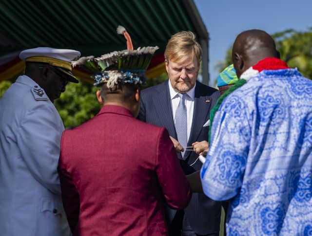 Koning Willem-Alexander houdt katoenen koord vast tijdens het offerritueel.