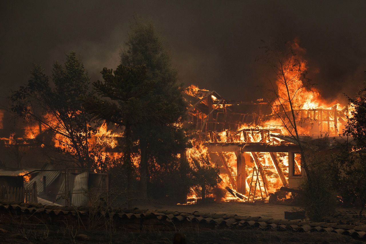 Een huis staat in brand in de buurt van Santa Juana, Chili. In deze stad kwamen elf mensen om het leven.
