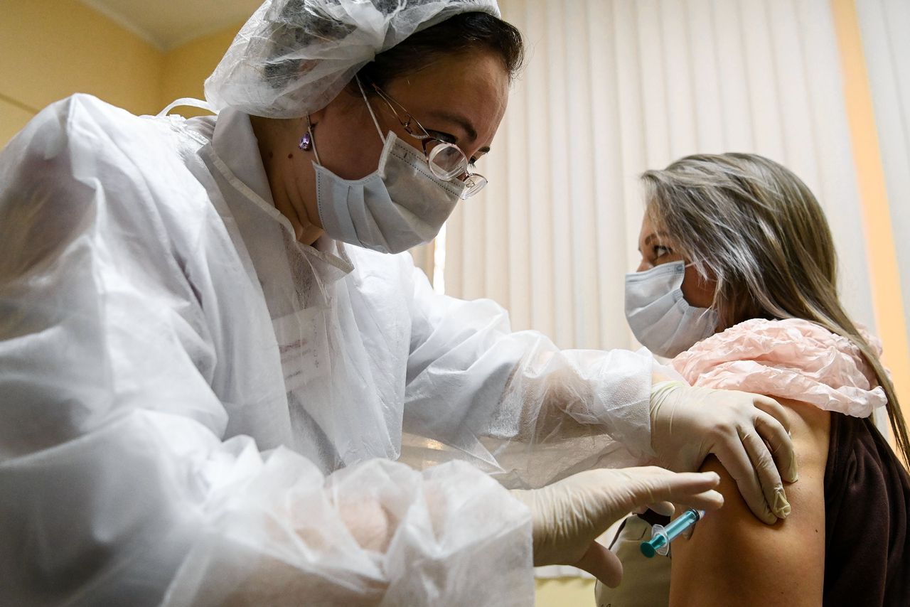 Een Russische verpleegster vaccineerde zaterdag iemand met het Sputnik-vaccin in een kliniek in Moskou.