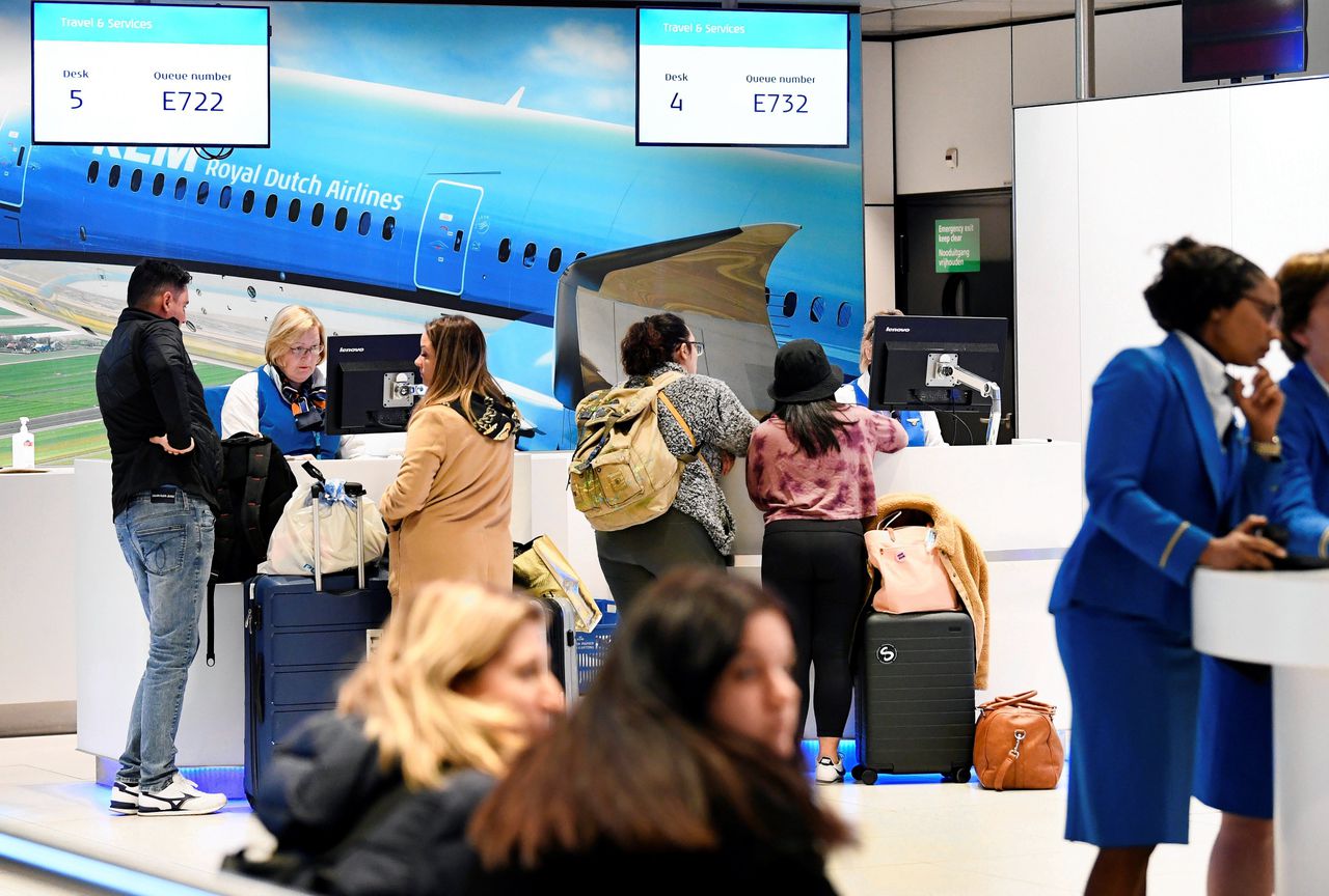 Passagiers wachten in de vertrekhal van Schiphol op informatie na het inreisverbod naar de VS dat president Donald Trump donderdagochtend heeft aangekondigd.
