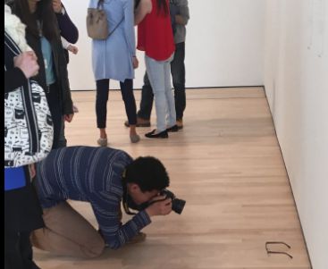Een museumbezoeker fotografeert het nepkunstwerk.