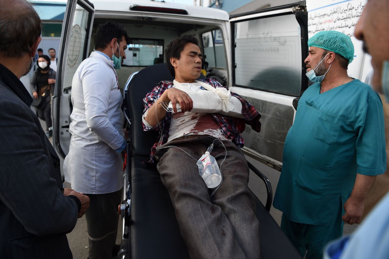 Een gewonde wordt afgevoerd nadat schutters de universiteit van Kabul bestormden.