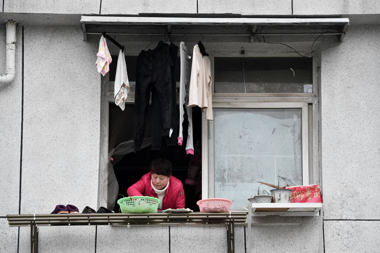 Een vrouw in Wuhan legt buiten eten te drogen.