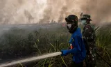 Brandweerlieden op het Indonesische eiland Sumatra bestrijden een natuurbrand in oktober 2015. De branden die elk jaar in het gebied woeden, waren dat jaar erger als gevolg van een El Niño.