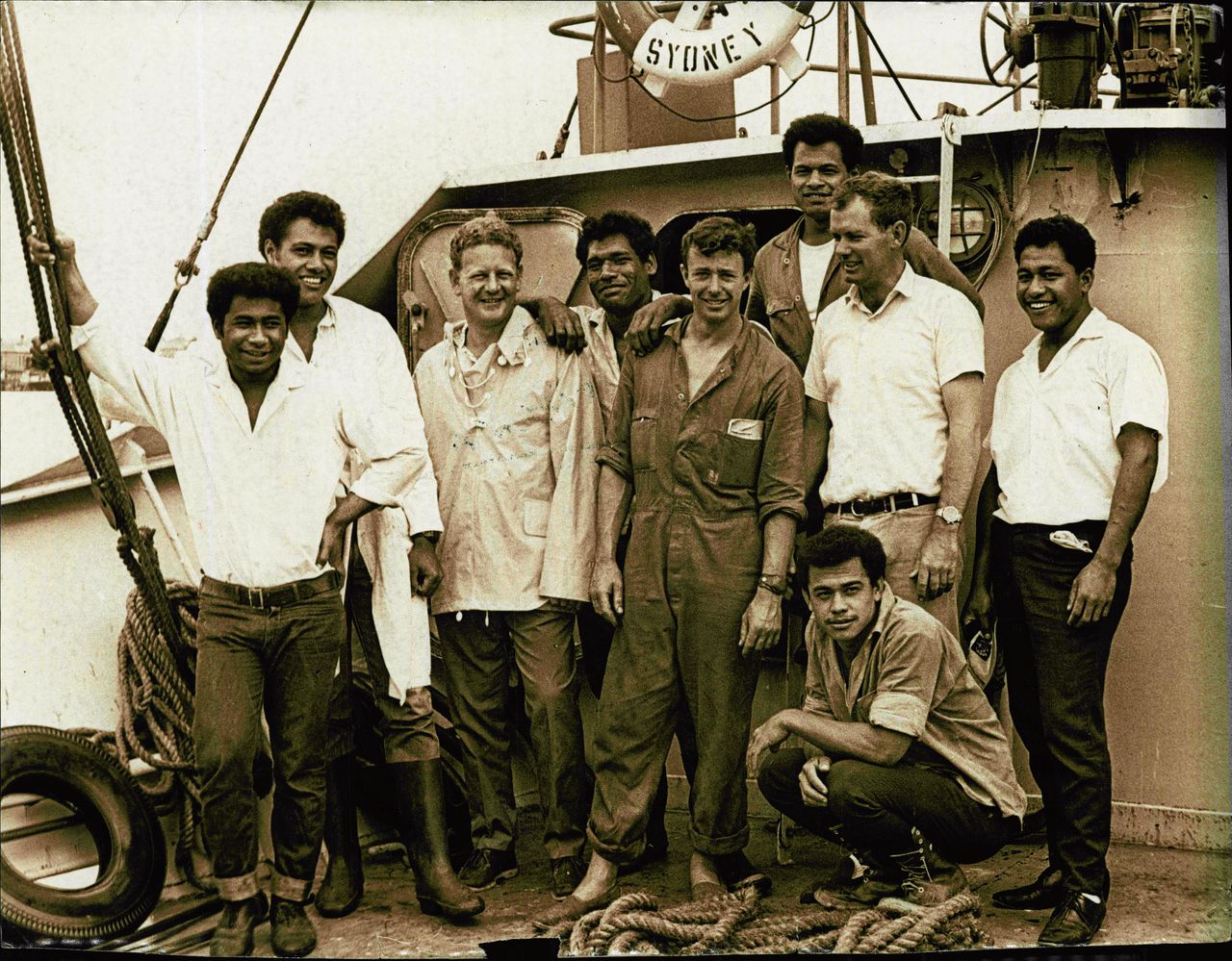 Kapitein Peter Warner (midden), met twee bemanningsleden en de zes jonge mannen die zij aantroffen op een onbewoond eiland.