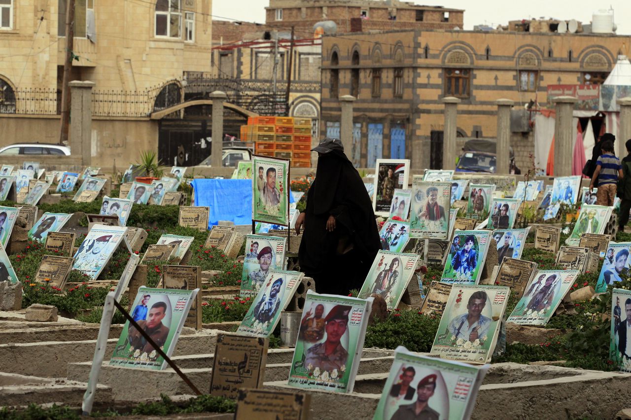 Een Jemenitische vrouw loopt door een kerkhof waar Houthi-rebellen liggen begraven.