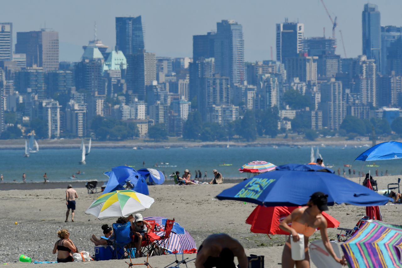 Mensen zoeken zondag verkoeling op het strand in de Canadese stad Vancouver tijdens een extreme hittegolf in de regio.