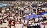 Strandgangers op Bondi Beach op eerste kerstdag. In Australië zijn alle stranden gratis en wordt het gezien als de grote maatschappelijke gelijkmaker.